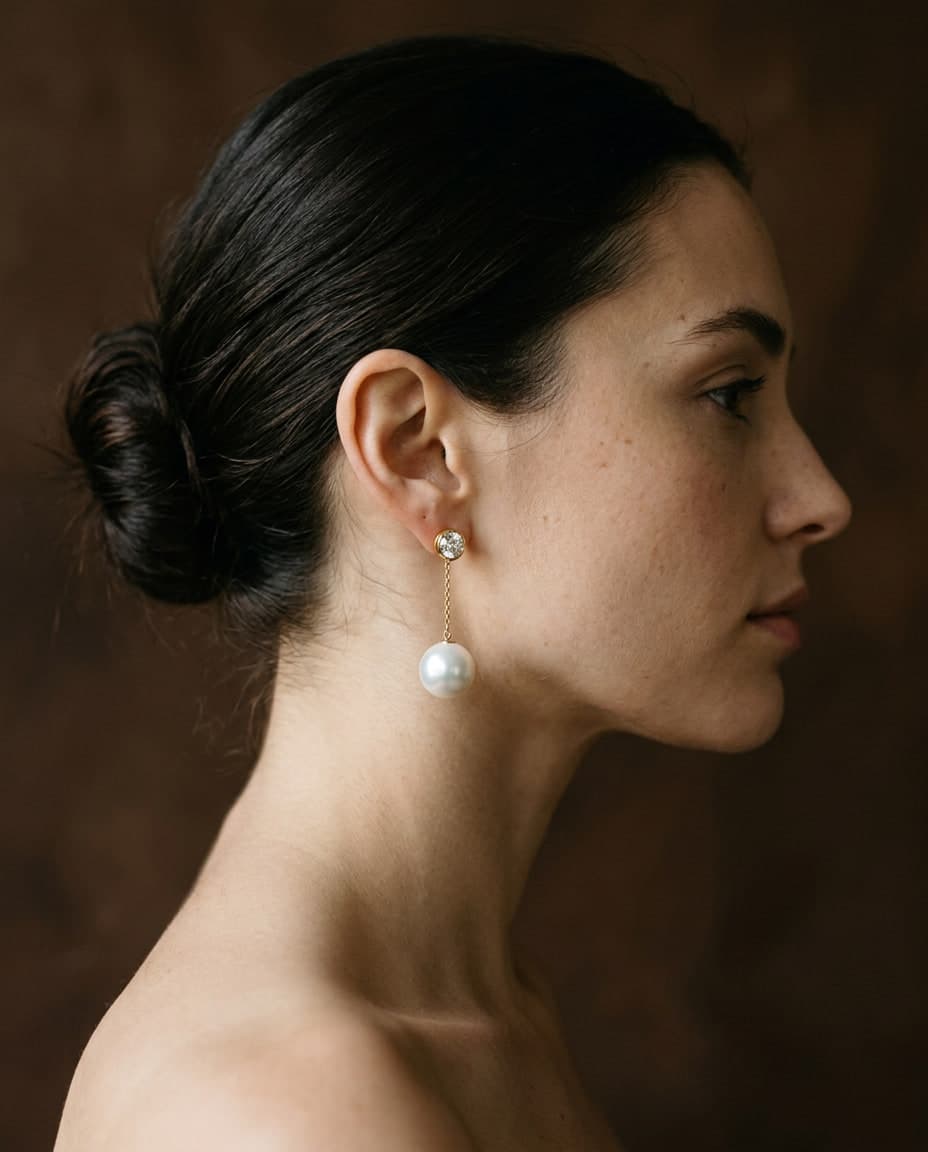 A woman in profile wearing a pearl drop earring